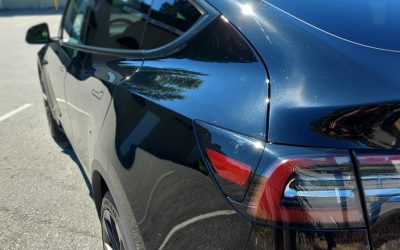 The tail light of a black Tesla after being professionally detailed
